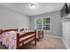 Bright bedroom with two twin beds, carpet, and a large window letting in plenty of natural light at 812 Deep Wood Ct, Fruitland Park, FL 34731