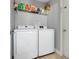 Bright laundry room with washer, dryer, and overhead shelving at 812 Deep Wood Ct, Fruitland Park, FL 34731