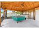 Open air backyard pool table with overhead lighting at 812 Deep Wood Ct, Fruitland Park, FL 34731