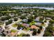 Expansive aerial view showcasing a residential neighborhood with manicured lawns, mature trees, and a tranquil lake at 887 Lancer Cir, Ocoee, FL 34761