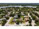 Wide aerial perspective of a residential community featuring well-kept homes, tree-lined streets, and a serene lake backdrop at 887 Lancer Cir, Ocoee, FL 34761