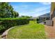 Lush backyard featuring a screened lanai, greenery, and a retaining wall at 887 Lancer Cir, Ocoee, FL 34761