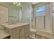 Bathroom featuring single sink vanity, framed mirror, wood look floor and tile shower/tub with decorative tile accents at 887 Lancer Cir, Ocoee, FL 34761