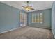 Spacious bedroom with blue walls, gray carpet, ceiling fan, and sliding doors to outside at 887 Lancer Cir, Ocoee, FL 34761