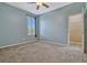 Carpeted bedroom with blue walls, ceiling fan, and ensuite bathroom at 887 Lancer Cir, Ocoee, FL 34761