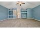 Spacious carpeted bonus room with fan, blue walls, and built-in shelves at 887 Lancer Cir, Ocoee, FL 34761