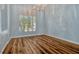Bright dining room featuring a modern chandelier, plantation shutters, and wood-look flooring at 887 Lancer Cir, Ocoee, FL 34761