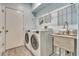 Laundry room with newer washer and dryer, utility sink and wire shelving at 887 Lancer Cir, Ocoee, FL 34761