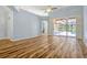 Bright living room featuring stylish wood floors, archways, and sliding glass doors overlooking the backyard at 887 Lancer Cir, Ocoee, FL 34761