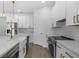Modern, all-white kitchen with stainless steel appliances, marble countertops, and gold hardware at 9265 Eagles Perch Pl, Orlando, FL 32825