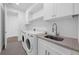 Well-equipped laundry room with modern washer and dryer, sink, countertop, and ample cabinet space at 9265 Eagles Perch Pl, Orlando, FL 32825