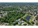Neighborhood aerial view showcasing a home with a pool next to a pond and lush tree coverage at 934 Jessamy St, Oviedo, FL 32765