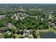 Expansive aerial view of home nestled among lush trees, featuring a private pool and neighborhood pond at 934 Jessamy St, Oviedo, FL 32765