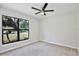 Well-lit bedroom with neutral carpet, a ceiling fan, and a large window at 934 Jessamy St, Oviedo, FL 32765