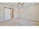 Bright bedroom with a ceiling fan, a sliding barn door, and neutral carpet at 934 Jessamy St, Oviedo, FL 32765