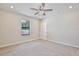 Neutral bedroom featuring a ceiling fan, window, and white door at 934 Jessamy St, Oviedo, FL 32765