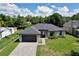 A charming single-story home featuring a manicured lawn, grey brick driveway, and dark grey trim at 934 Jessamy St, Oviedo, FL 32765
