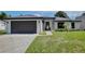 Charming single-story home with lush green lawn, stone accents, and a dark-colored two car garage at 934 Jessamy St, Oviedo, FL 32765