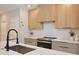 Stylish kitchen featuring a white backsplash, quartz countertops, and stainless steel appliances at 934 Jessamy St, Oviedo, FL 32765