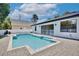 Backyard view of a refreshing pool surrounded by a gray brick paver patio and a well manicured lawn at 934 Jessamy St, Oviedo, FL 32765