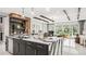 Open-concept kitchen featuring a waterfall island, bar seating, and views of the dining and living areas at 960 Club Cresswind Dr, Lady Lake, FL 32159