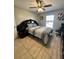 Comfortable bedroom featuring a ceiling fan, tiled flooring and a bright window at 112 Tulip Ln, Kissimmee, FL 34759