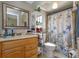 Cozy bathroom with seashell shower curtain, a wood vanity and mirror, plus convenient shelving at 11435 Aries Dr, Orlando, FL 32837