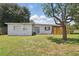 Well-maintained backyard featuring green grass, a new wooden fence, and mature trees at 1301 Lawne Blvd, Orlando, FL 32808