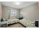 Cozy bedroom featuring two twin beds, wood floors, and a bright window with charming curtains at 1301 Lawne Blvd, Orlando, FL 32808