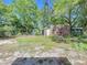 Spacious backyard featuring mature trees, partial fencing, and two storage sheds at 1307 Jean Ct, Eustis, FL 32726