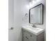 Bathroom vanity with grey cabinets, stylish mirror and modern fixtures at 1307 Jean Ct, Eustis, FL 32726