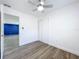 Bedroom with wood-look flooring, closet, and doorway view into a blue accent-walled living room at 1307 Jean Ct, Eustis, FL 32726