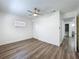 Well-lit bedroom boasts wood-look floors, a closet, ceiling fan, and a glimpse into the bathroom at 1307 Jean Ct, Eustis, FL 32726