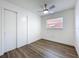 Bright bedroom with wood-look floors, ceiling fan, closet, and window at 1307 Jean Ct, Eustis, FL 32726
