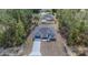 An aerial view showcases a modern home with expansive lot, a long driveway, and lush surrounding greenery at 13419 Sw 77Th Ave, Ocala, FL 34473