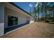 Exterior view of home backyard with exterior sink, sliding glass door, and mature trees at 13419 Sw 77Th Ave, Ocala, FL 34473