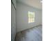 Bright bedroom featuring wood-look flooring and a large window overlooking a fenced yard at 13419 Sw 77Th Ave, Ocala, FL 34473