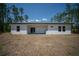 Backyard of home with covered patio and outdoor sink; showcasing mature trees and ample space at 13419 Sw 77Th Ave, Ocala, FL 34473