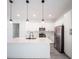 This kitchen features pristine white cabinetry, stainless steel appliances, a center island and modern pendant lighting at 13419 Sw 77Th Ave, Ocala, FL 34473