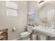 Cozy half bathroom showcasing a pedestal sink, decorative mirror, and neutral color palette at 14781 Old Thicket Trce, Winter Garden, FL 34787