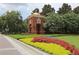 Charming community entrance featuring lush landscaping, brick architecture, and manicured flower beds at 14781 Old Thicket Trce, Winter Garden, FL 34787