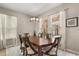 Formal dining room with a large wood table, elegant chandelier, and natural light from surrounding windows at 14781 Old Thicket Trce, Winter Garden, FL 34787