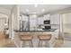 Bright kitchen boasts white cabinetry, stainless steel appliances, a breakfast bar with seating, and tile flooring at 14781 Old Thicket Trce, Winter Garden, FL 34787
