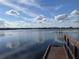 Picturesque lake view from a wooden dock, with tranquil water and clear blue skies at 14781 Old Thicket Trce, Winter Garden, FL 34787