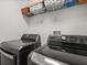 Modern laundry room with sleek, dark appliances and ample storage at 14781 Old Thicket Trce, Winter Garden, FL 34787