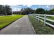 Community sidewalk and greenway with white fence on a sunny day at 14781 Old Thicket Trce, Winter Garden, FL 34787