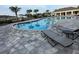 Community pool featuring lounge chairs, palm trees, and a spacious deck area for relaxation at 17148 Cagan Crossings Blvd, Clermont, FL 34714