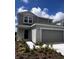 Charming two-story home with a gray exterior, a two-car garage, and well maintained landscaping at 17148 Cagan Crossings Blvd, Clermont, FL 34714
