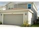 Two-story home with a gray exterior, a two-car garage, and well maintained landscaping at 17148 Cagan Crossings Blvd, Clermont, FL 34714