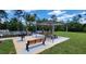 Outdoor grilling and picnic area with a barbecue grill, benches, and shade structure at 17148 Cagan Crossings Blvd, Clermont, FL 34714